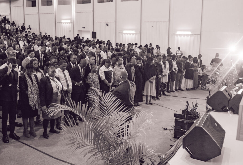 The plenary hall standing in worship
