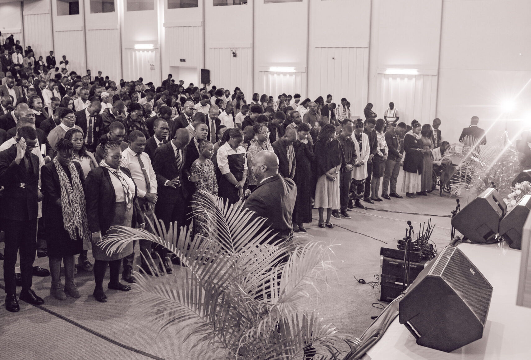 Delegates standing in worship in the plenary hall at GYC Africa 2026 in Lusaka