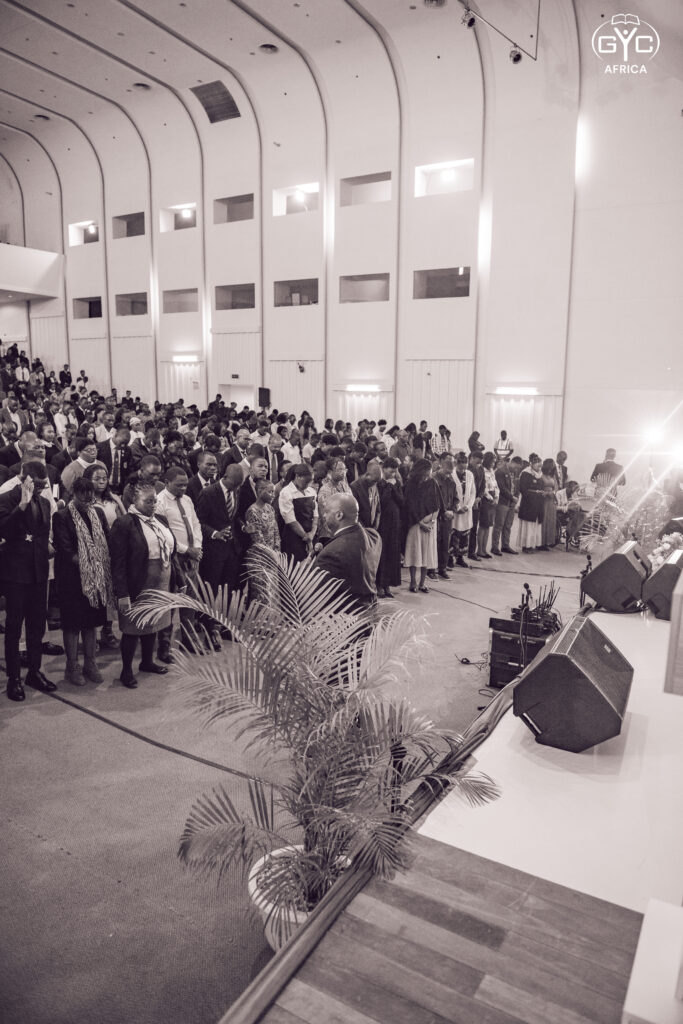 Black and white view of the full plenary hall in worship