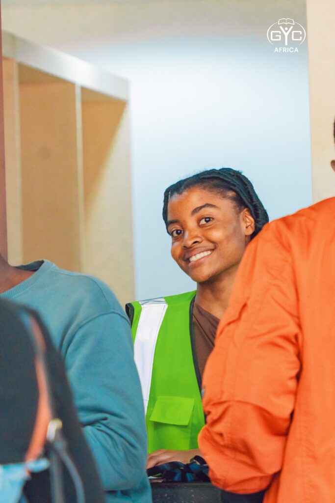 A smiling volunteer welcomes delegates on opening night