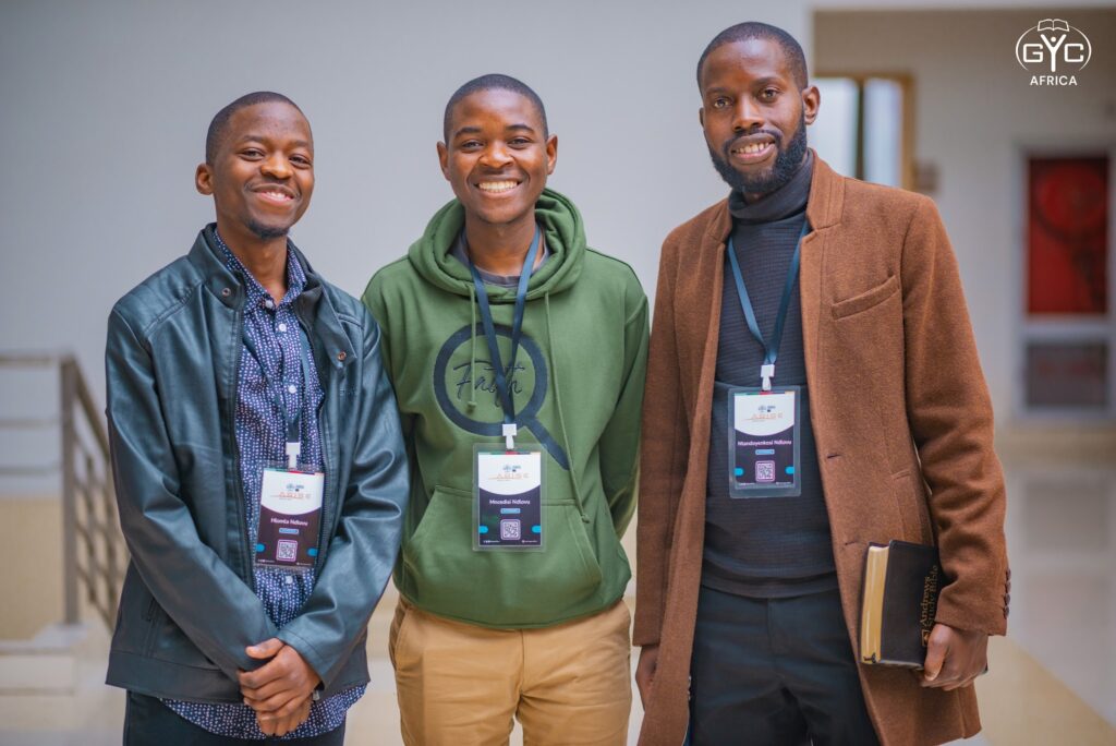 Three young delegates smile together