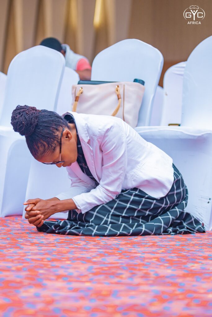 A delegate kneels in prayer